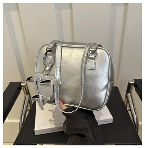 Detailed shot of silver metallic leather boston bag with a heart bow charm accessory