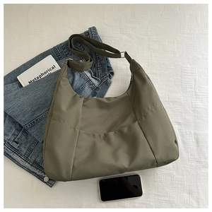 Détail du sac fourre-tout en toile vert olive avec bandoulière réglable sur tissu