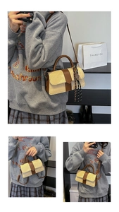 Detail view of beige canvas crossbody bag with brown leather trim and woven cord charm