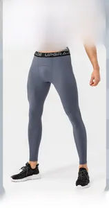 Detail of grey compression pants showing elastic waistband with UPGRADE lettering and high elasticity