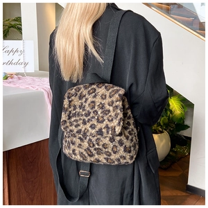 Détail d'un sac à dos en peluche léopard avec des bretelles réglables en textile noir