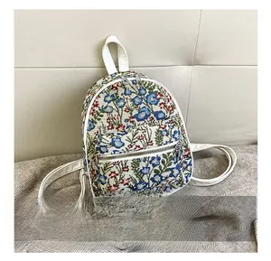 Detailed size comparison of a floral jacquard mini backpack next to a smartphone