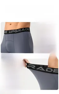 Detail of gray athletic shorts showing wide logo waistband and high elastic fabric stretch