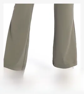 Détail du pantalon de yoga vert olive montrant le tissu extensible et la texture du bas