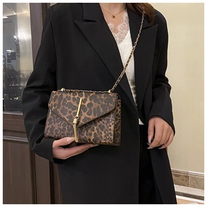 Detail der Schultertasche mit Leopardenmuster, Goldkette und dekorativer Quaste