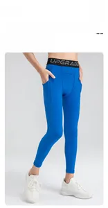 Detail of boys compression leggings featuring side pockets and elastic logo waistband