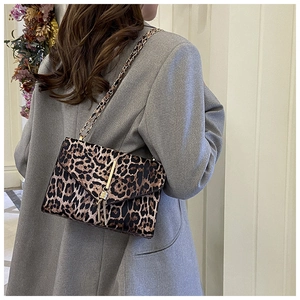 Detail der Schultertasche mit Leopardenmuster, Goldkette und Quaste am Modell