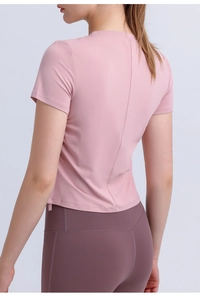 Back view of a pink short sleeve crop top and high-waisted burgundy yoga leggings