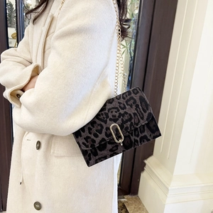 Sac à bandoulière tendance à imprimé léopard avec chaîne dorée sur manteau beige