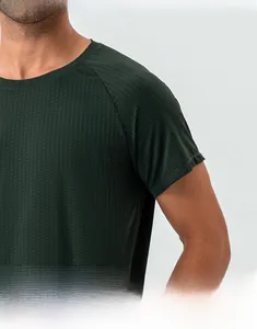 Close-up of raglan sleeves and breathable mesh fabric on men's dark green sports t-shirt