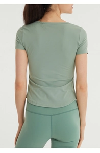 Back view of fitted short-sleeve yoga top and leggings with visible stitching details
