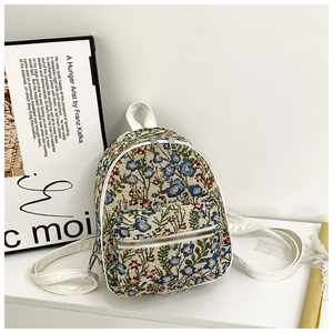 Detail of floral jacquard mini backpack showing woven fabric and white zipper strap