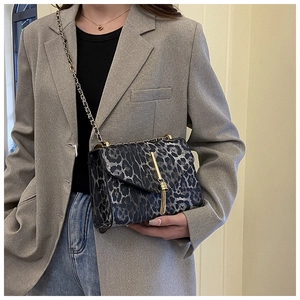 Detail der Handtasche mit Leopardenmuster, Goldkette und Metallquasten-Akzent