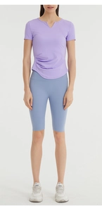 Detail view of purple yoga t-shirt side ruching and breathable athletic fabric texture