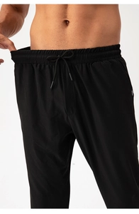Detail of men's athletic pants featuring a drawstring waist and branded side pocket tag