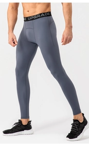 Detail of gray athletic compression leggings showing high-elasticity fabric and waistband