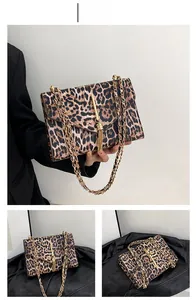 Detail der Handtasche mit Leopardenmuster, goldenem Metallstab und elegantem Quastenanhänger