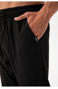 Detail of men's quick-dry sport pants featuring an elastic drawstring waist and woven label