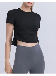 Detail of black cropped sports tee showing side drawstring and high-waist yoga pants