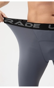 Detail of high-stretch fabric showing superior elasticity on men's gray compression pants