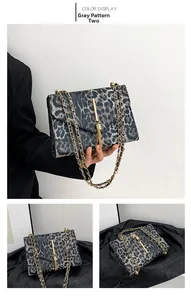Detailansicht der grauen Handtasche mit Leopardenmuster, Goldketten und Fransen-Magnetverschluss