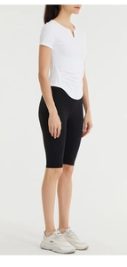Detail of white V-neck workout top with side ruching and black cycling shorts