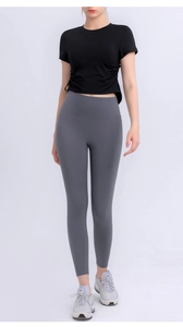 Detail of drawstring side ruching on women's cropped workout top with high waist leggings