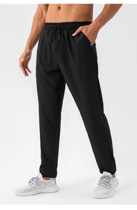 Detail view of men's black quick-dry joggers with elastic drawstring waist and side pockets