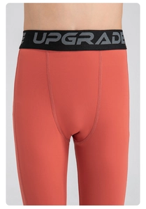 Détail du pantalon de compression rouge avec taille élastique et lettrage UPGRADE