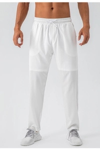 Detail of white quick-dry sports trousers featuring an elastic waist and drawstring