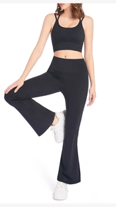 Détail du pantalon de yoga évasé taille haute avec brassière de sport à dos croisé en noir