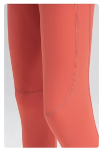 Détail du pantalon de sport rouge brique avec couture plate professionnelle à quatre aiguilles