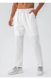 Detail of white quick-dry sports trousers featuring elastic waist with drawstring and pocket tag