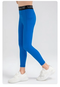 Detail of high-waisted royal blue leggings with elastic logo waistband and side pockets