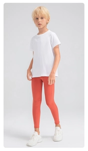 Détail du pantalon de compression orange corail pour enfant avec bande latérale