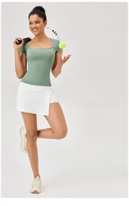 Dettaglio di una donna con t-shirt sportiva verde salvia a collo quadrato e gonna