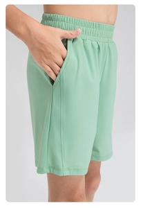 Détail du short de sport vert clair pour garçon avec taille élastique et poches latérales