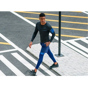Close-up of men's compression long sleeve top and layered sports leggings on urban track