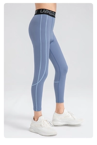 Detail of high-waisted fog blue yoga pants with black elastic waistband and UPGRADE lettering