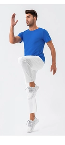Action shot of men's quick-dry sports set featuring blue t-shirt and white running pants