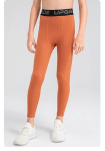 Detail view of boys orange compression pants with elastic branded waistband and breathable fabric