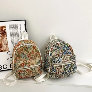 Mini floral tapestry backpack with white leather trim and adjustable shoulder straps