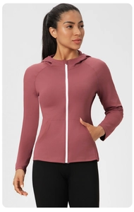 Détail de la veste de yoga rose ajustée avec capuche et fermeture éclair blanche
