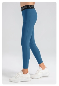 Détail de leggings de sport enfant à séchage rapide avec lettrage UPGRADE élastique