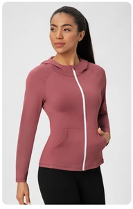 Veste de yoga à capuche rose poudré avec fermeture éclair blanche et poches latérales