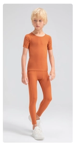 Close-up of boys orange compression sports set featuring breathable high-stretch fabric