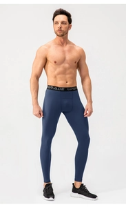 Detail of men's navy blue compression leggings featuring a wide black elastic waistband