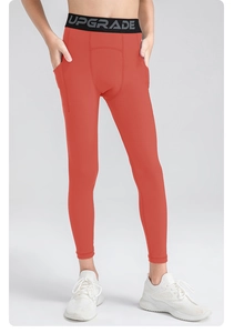 Close-up of kids compression leggings with side pocket and UPGRADE logo waistband