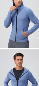 Detail of blue men's athletic jacket with zipper, hood, and breathable textured fabric