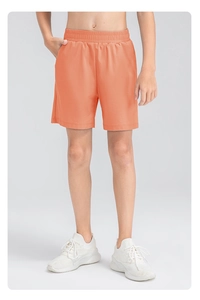 Détail du short de sport orange à séchage rapide avec taille élastique et poches latérales